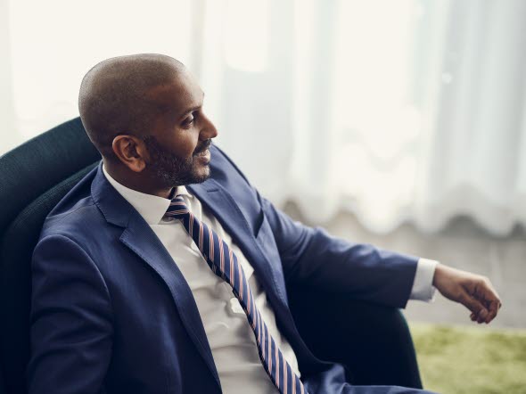 Man in a tie sitting in an armchair