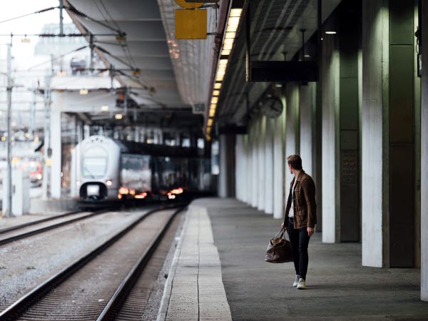 A man turning around watching a train arrive