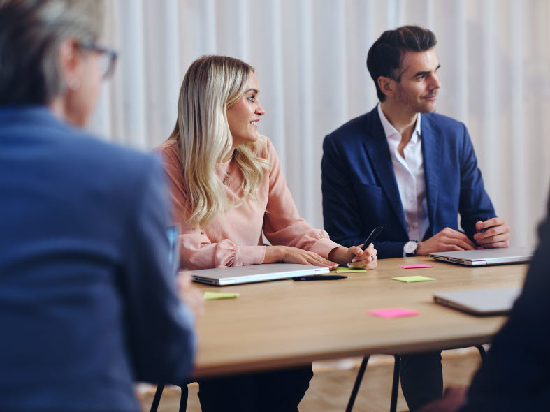 Three people sitting at an office table discussing