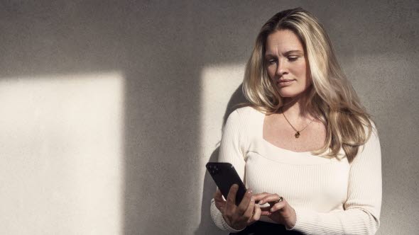 Picture of a woman looking at the screen of her mobile phone